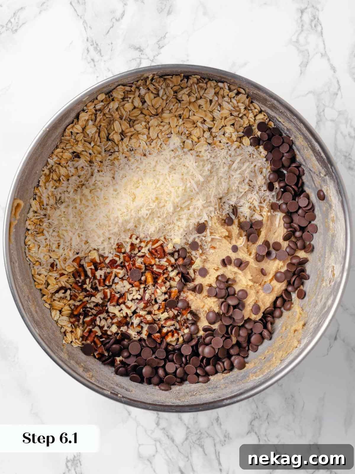Hearty Cowboy Cookie Bake 13 A vibrant array of chocolate chips, old-fashioned oats, and chopped pecans resting atop the partially mixed cookie dough, poised to be folded in for ultimate flavor.