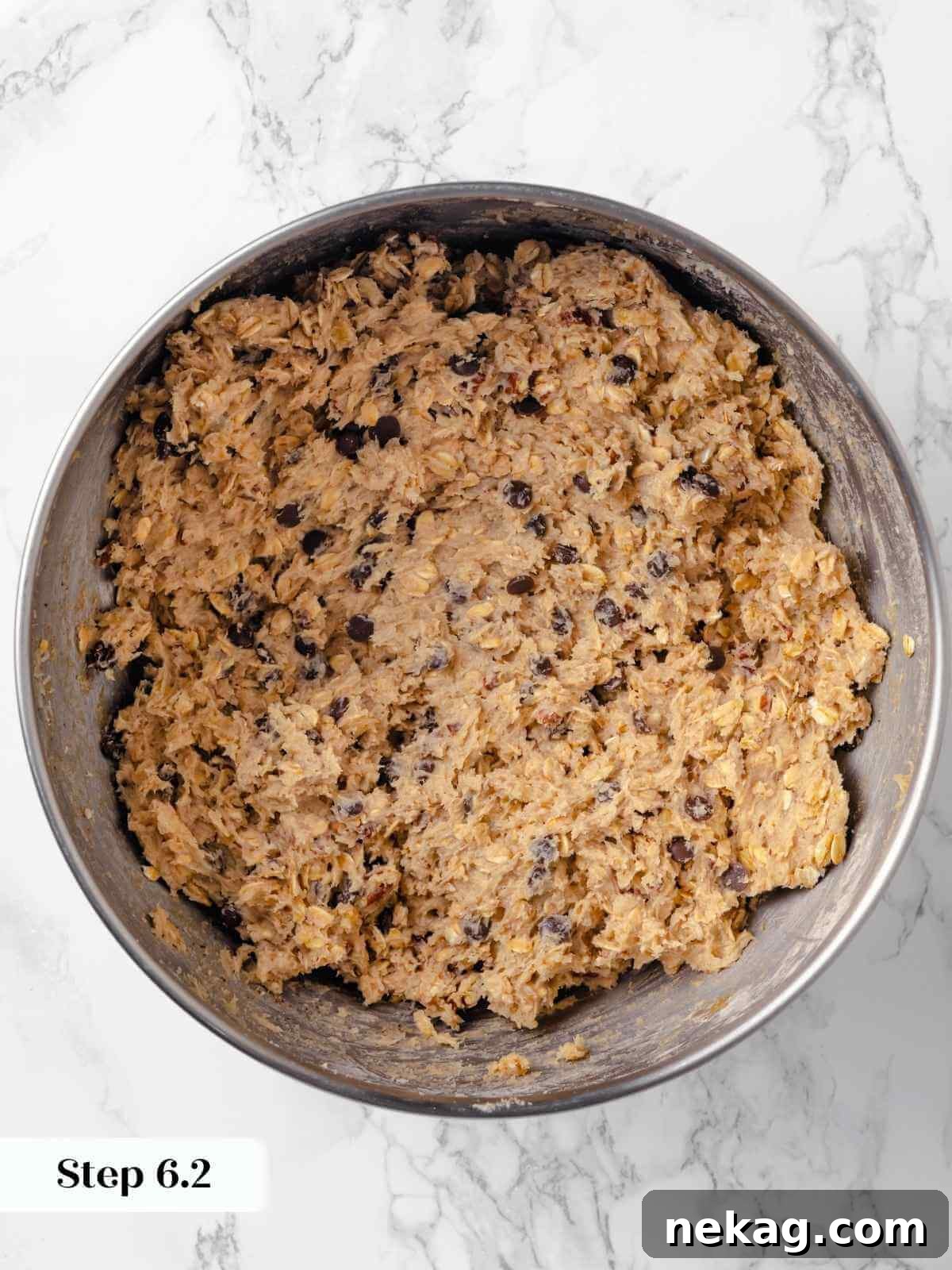 Hearty Cowboy Cookie Bake 14 An enticing view of chocolate chips, oats, and pecans perfectly folded into the rich cookie dough mixture, ensuring every bite is loaded with wholesome goodness and flavor.