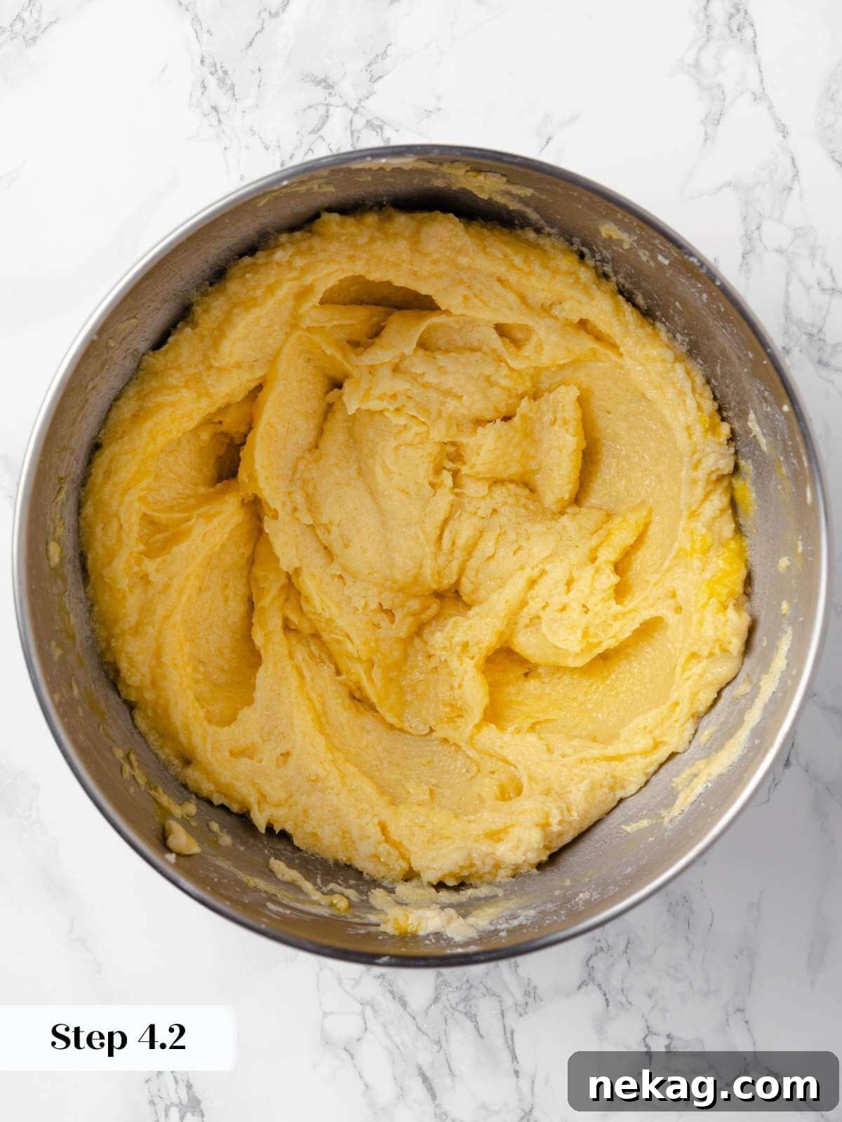 Hearty Cowboy Cookie Bake 10 A smooth, well-combined cookie dough in a mixing bowl after an egg has been fully incorporated, displaying a consistent texture ready for the next addition.