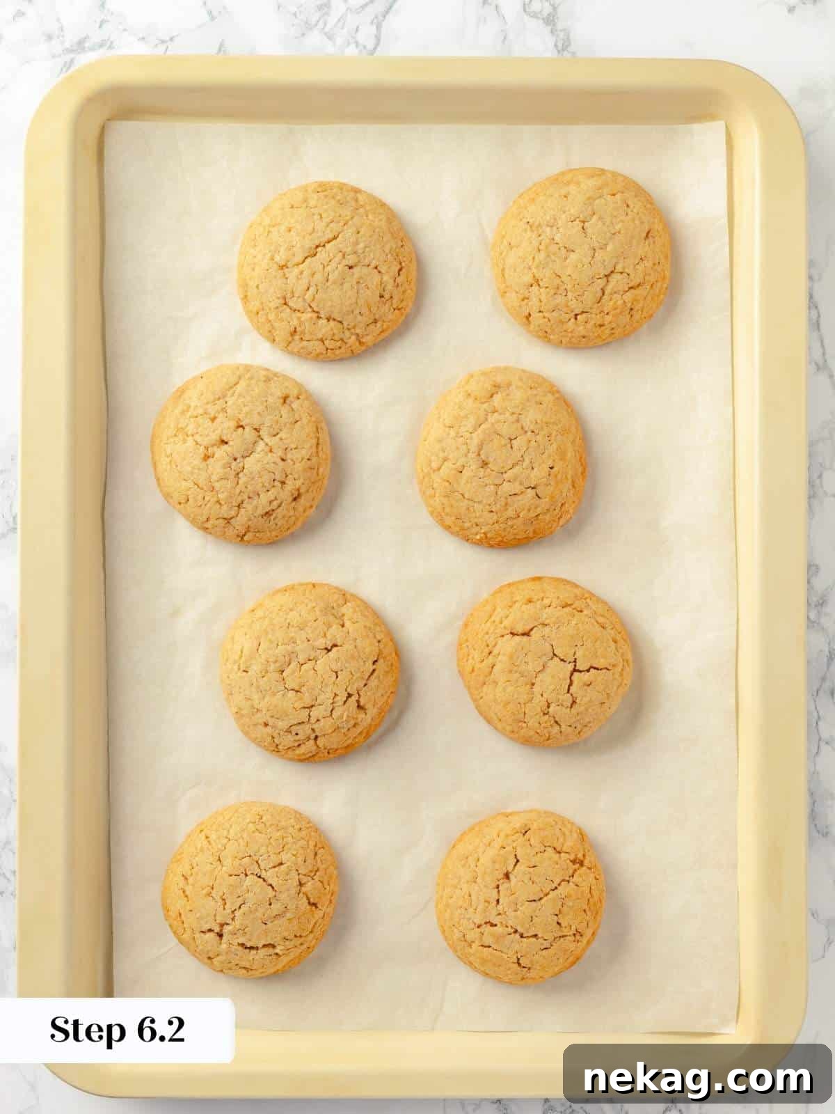 Baked chai sugar cookies cooling on a parchment-lined sheet.