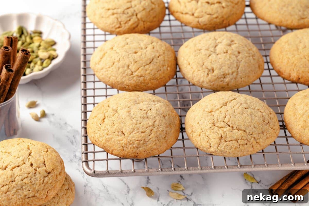 Close-up of golden brown chai sugar cookies on a cooling rack, highlighting their texture.