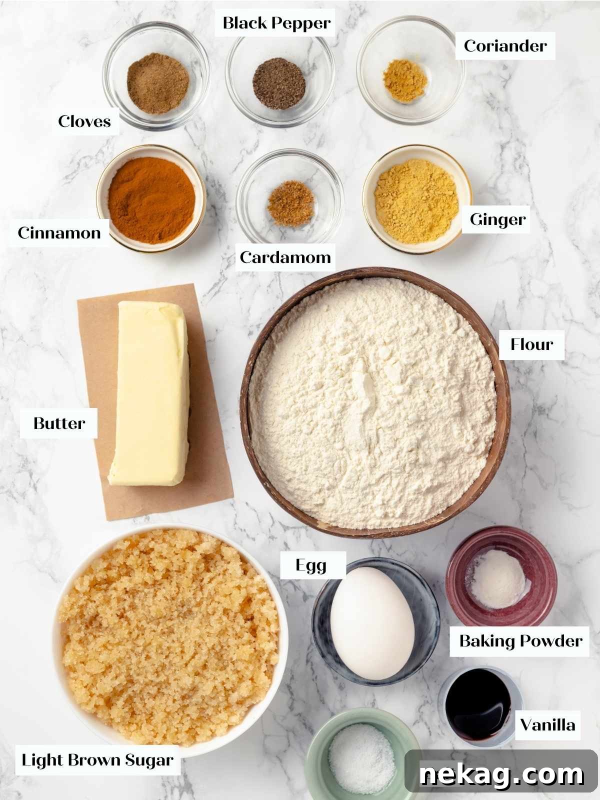 Assortment of spices and baking ingredients laid out on a table, including cinnamon, cardamom, and brown sugar.