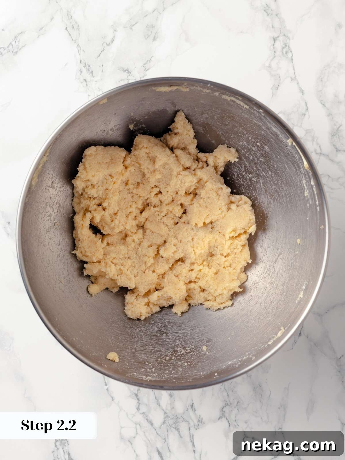 Adding dry ingredients to the wet mixture in a stand mixer.