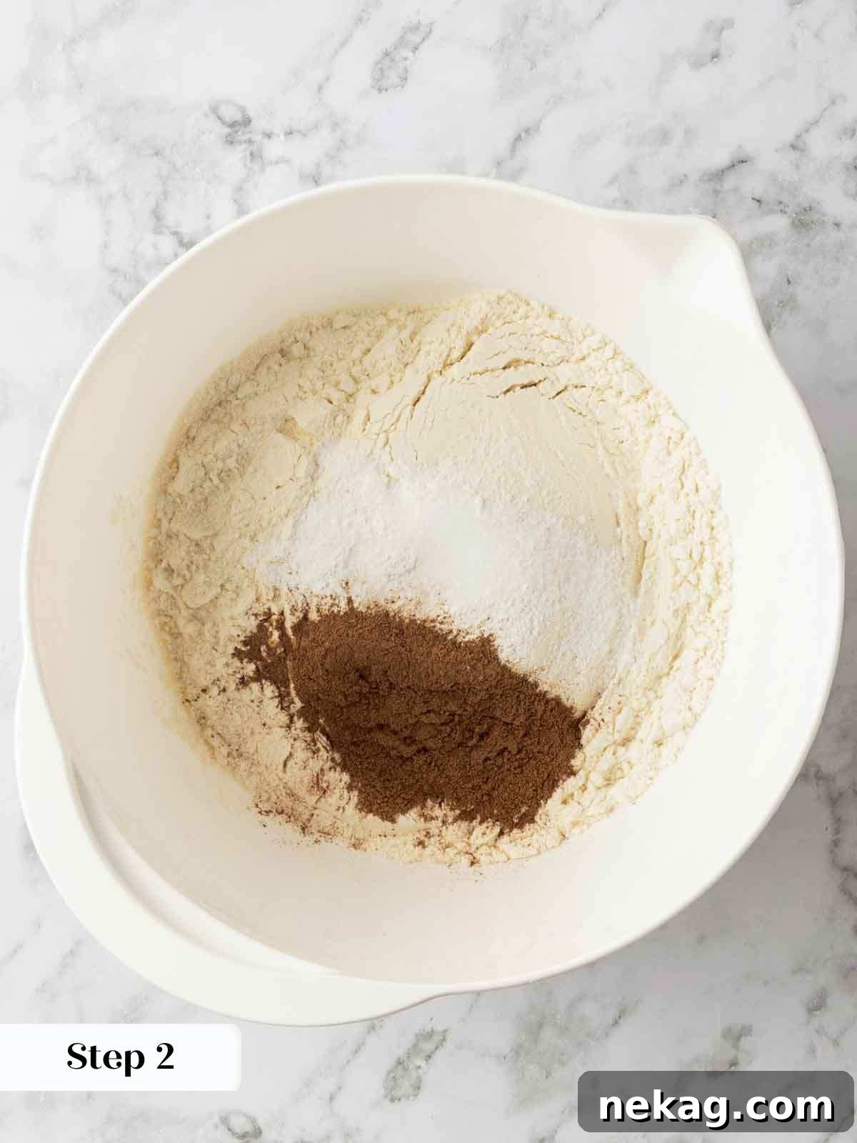 A close-up shot of dry ingredients for banana cake, including flour, cinnamon, salt, and baking powder, perfectly unmixed and ready to be combined.