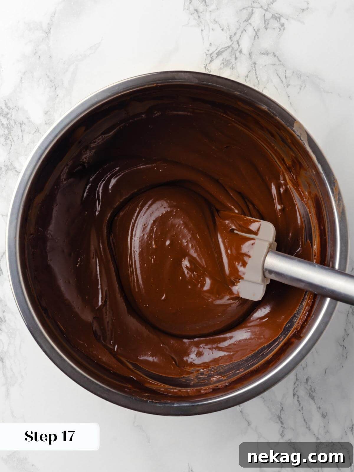 A bowl of silky chocolate ganache freshly mixed and glossy, ready to use for decorating the chocolate raspberry cake.