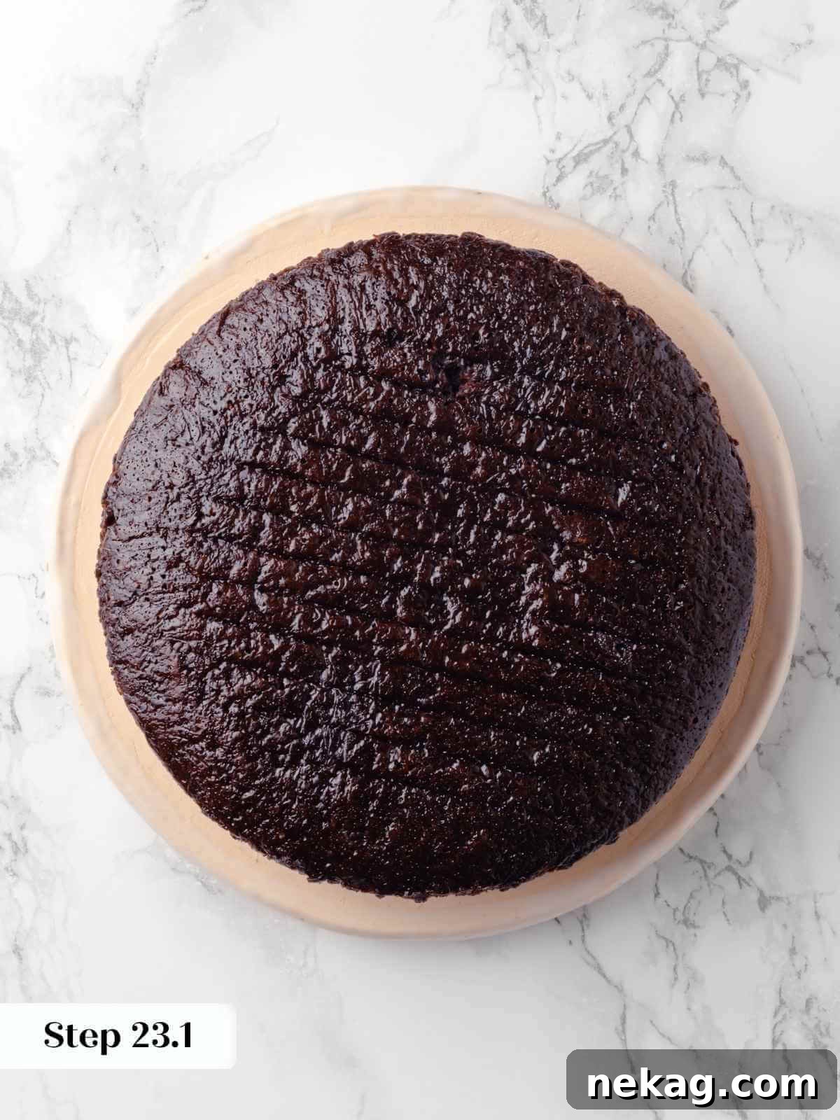 The first layer of the chocolate raspberry cake, unadorned and ready for frosting, sitting on a cake stand.