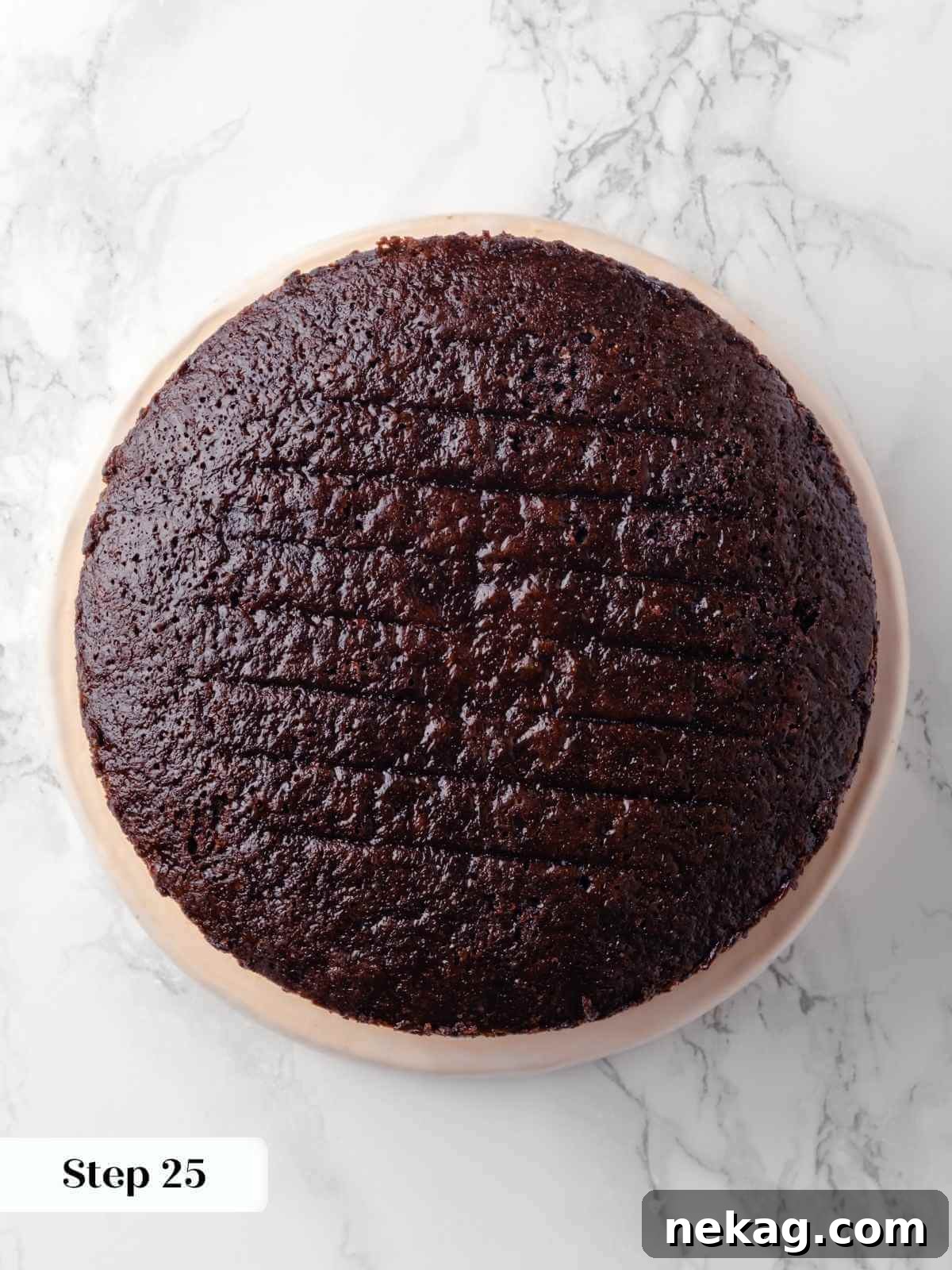 The second layer of the chocolate raspberry cake placed on top, unadorned and ready for the next filling.
