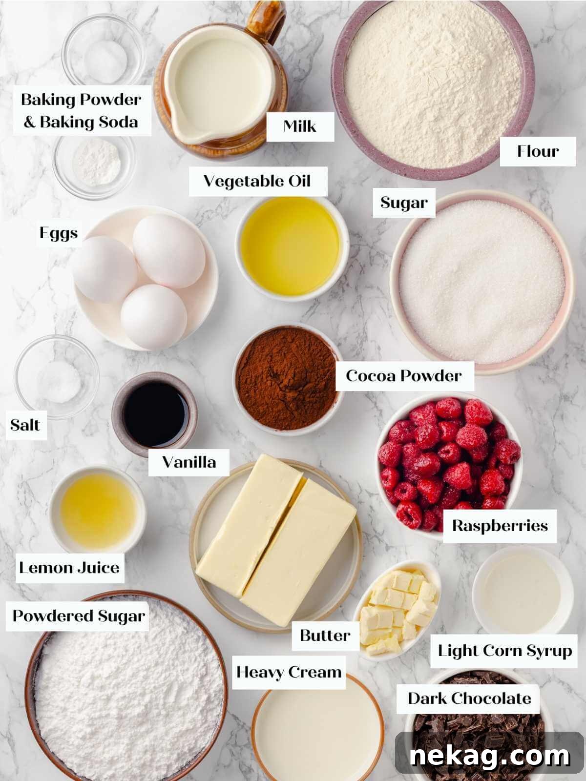 A flat lay of various ingredients for a chocolate raspberry cake, including cocoa powder, flour, eggs, and fresh raspberries, arranged neatly on a white marble surface.