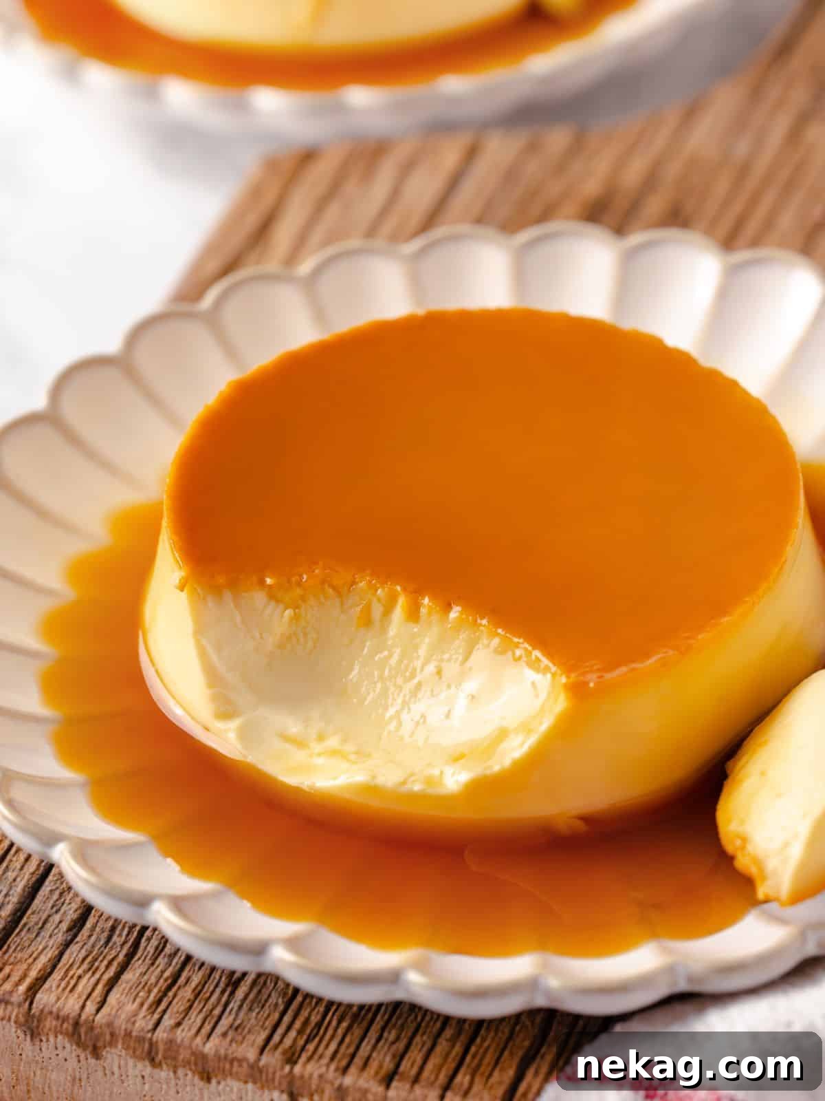 Silky Caramel Custard 2 A creme caramel dessert with a bite taken out, revealing its creamy, smooth texture.