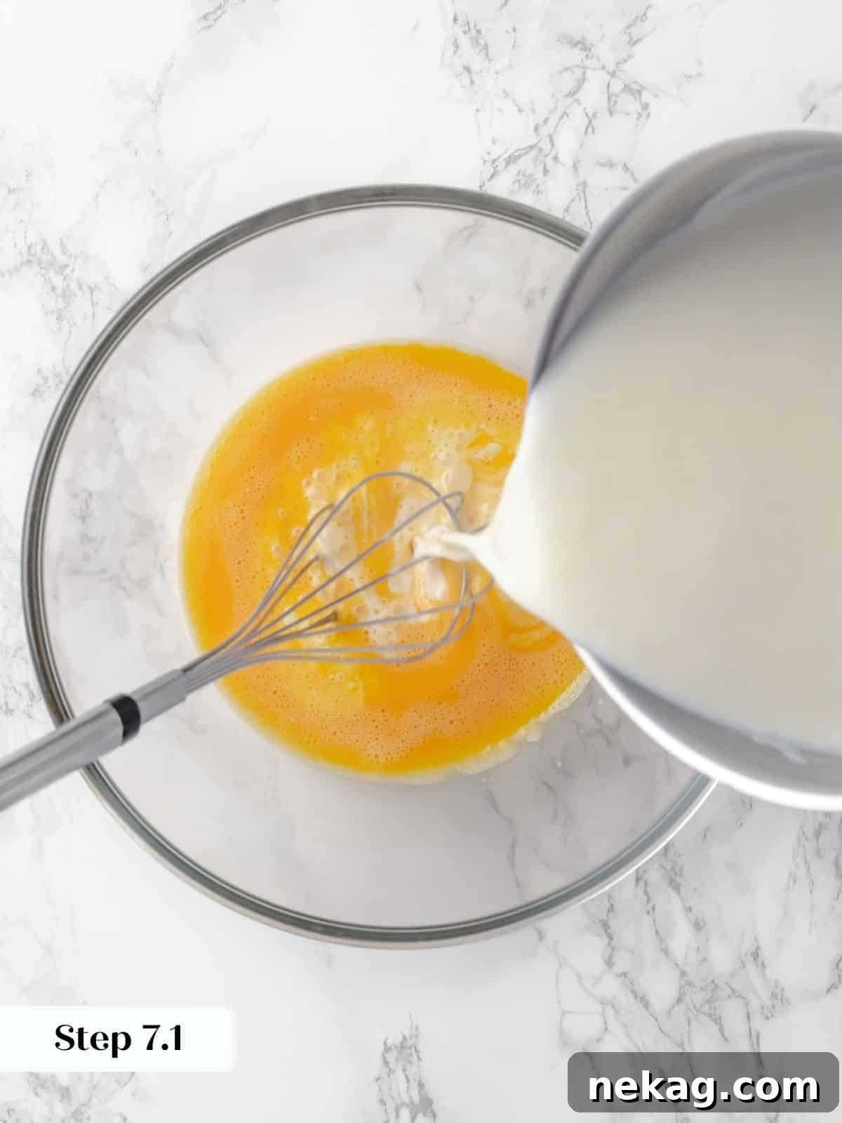 Silky Caramel Custard 12 Warm milk being poured into whisked eggs, tempering them for the custard mixture.