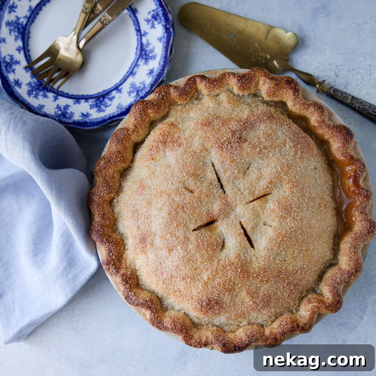 A perfectly baked Mile High Apple Pie, golden-brown and glistening, ready for slicing and serving.