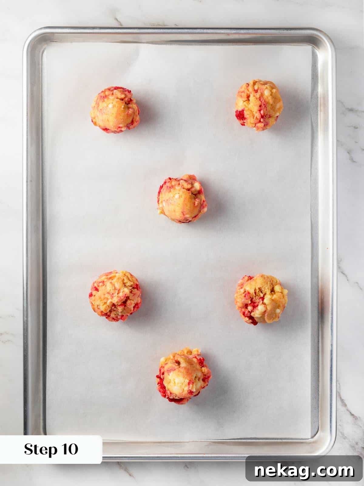 Cookie dough balls portioned onto a baking sheet, ready to go into the oven.
