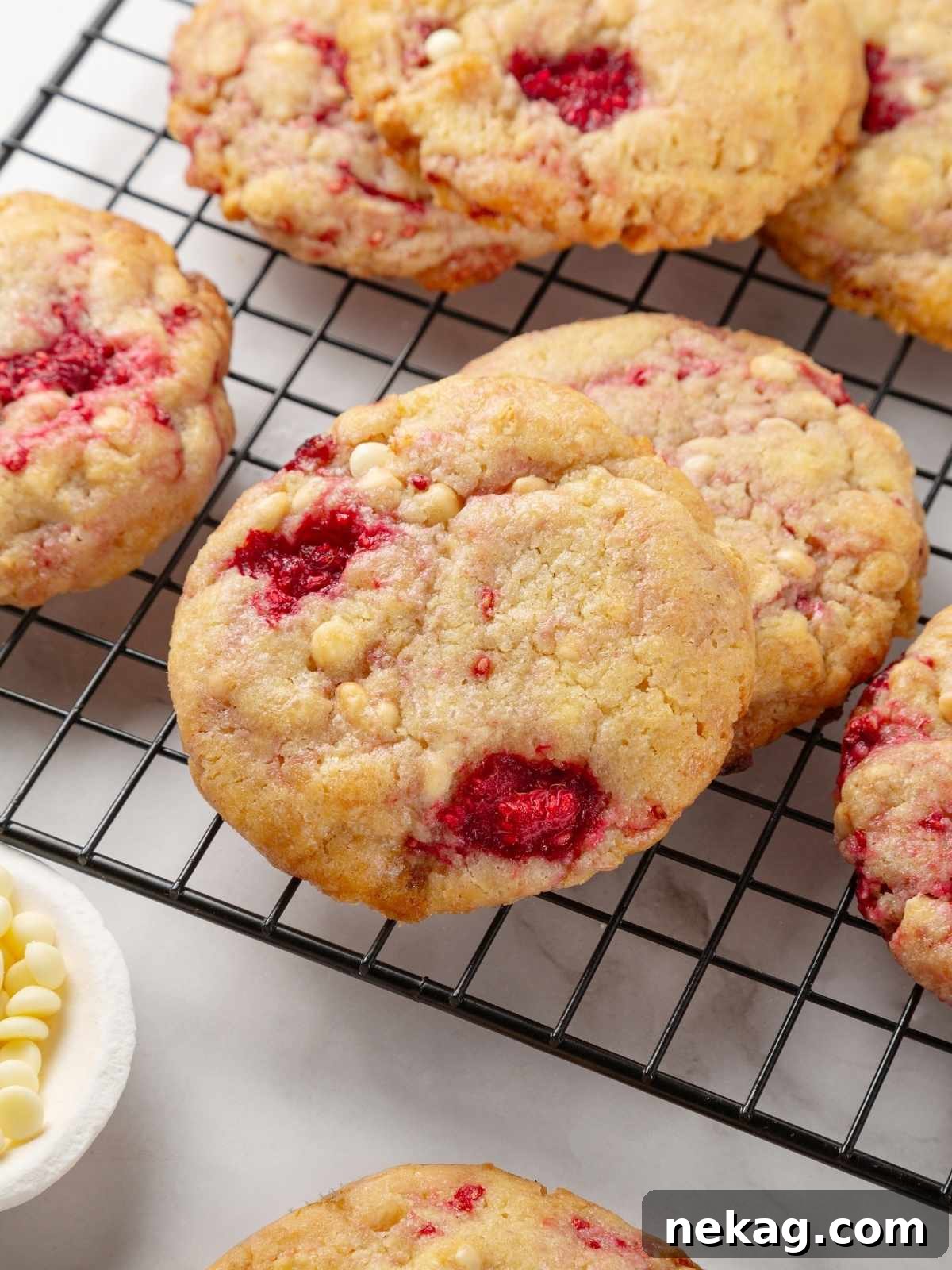 White chocolate raspberry cookies cooling on a wire rack, ready to be enjoyed.