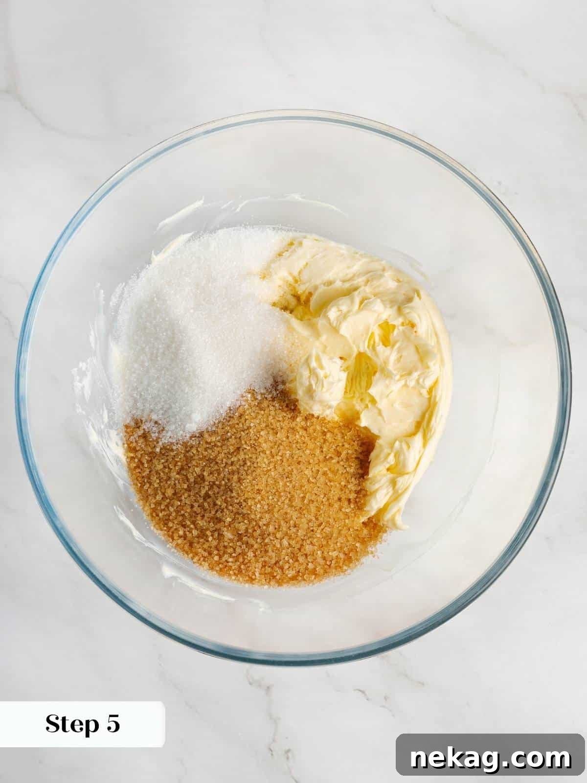 Granulated and brown sugar being mixed with softened butter to create a creamy base for the cookies.