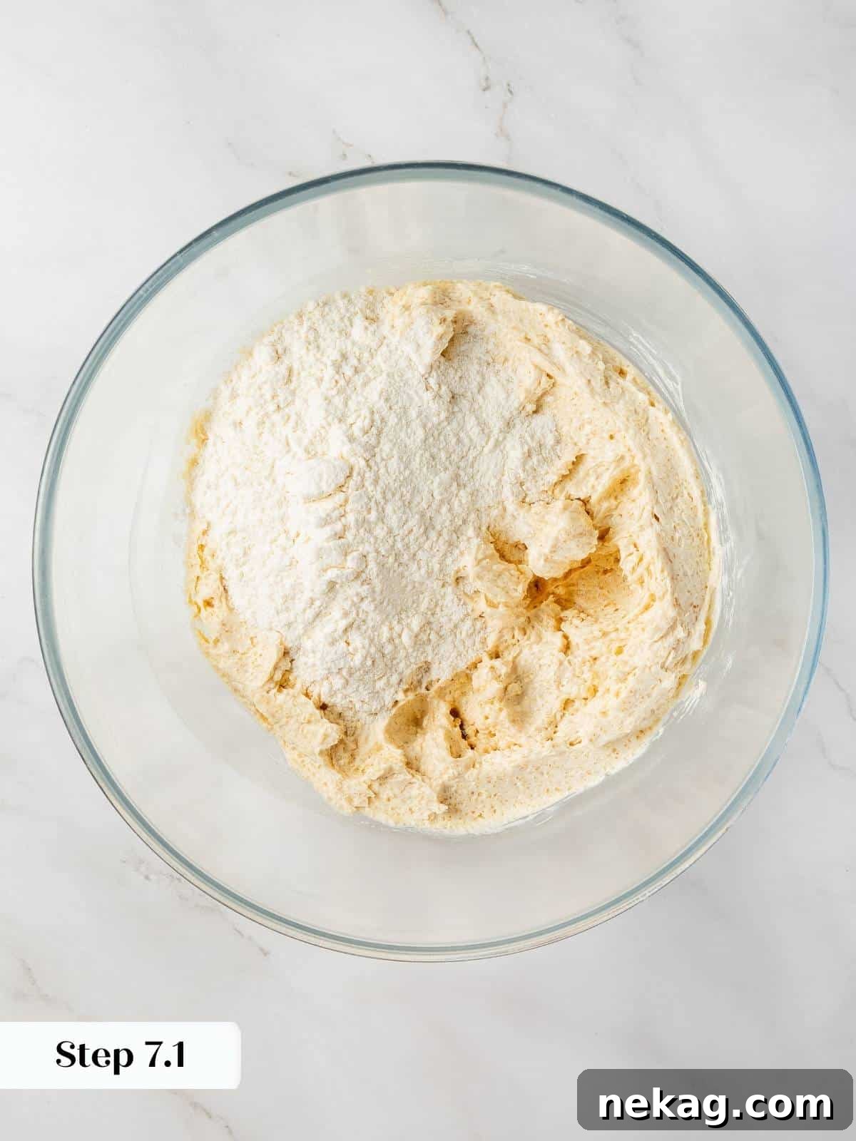 Flour mixture being gradually added to the wet ingredients to form the cookie dough.