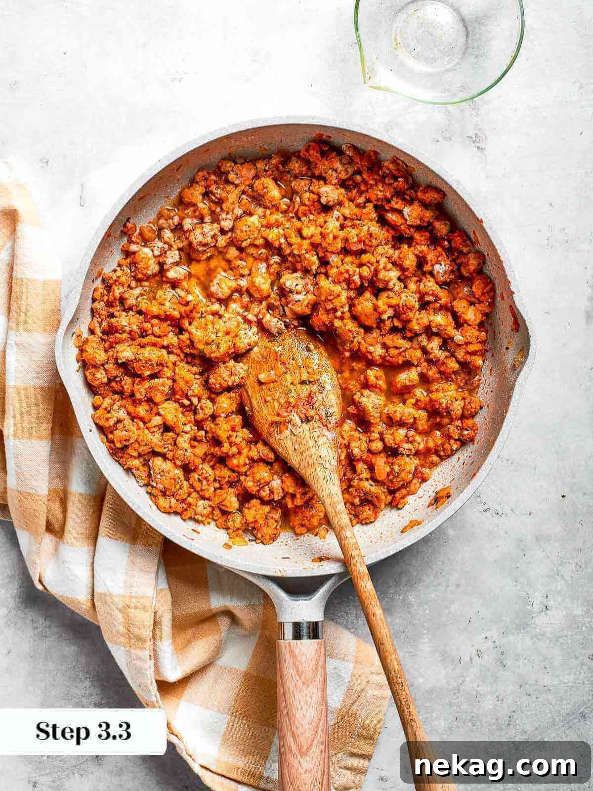A pan of fully cooked ground chicken filling, rich with golden-brown seasoning and a thick, savory sauce.