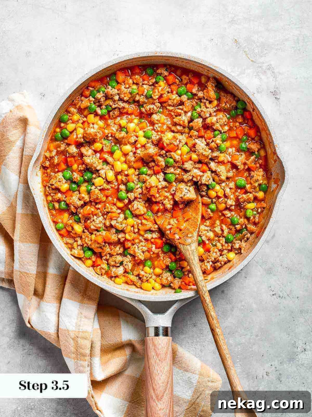 A pan filled with soft, seasoned chicken and vegetables, gently steaming and rich in color, indicating it's perfectly cooked.