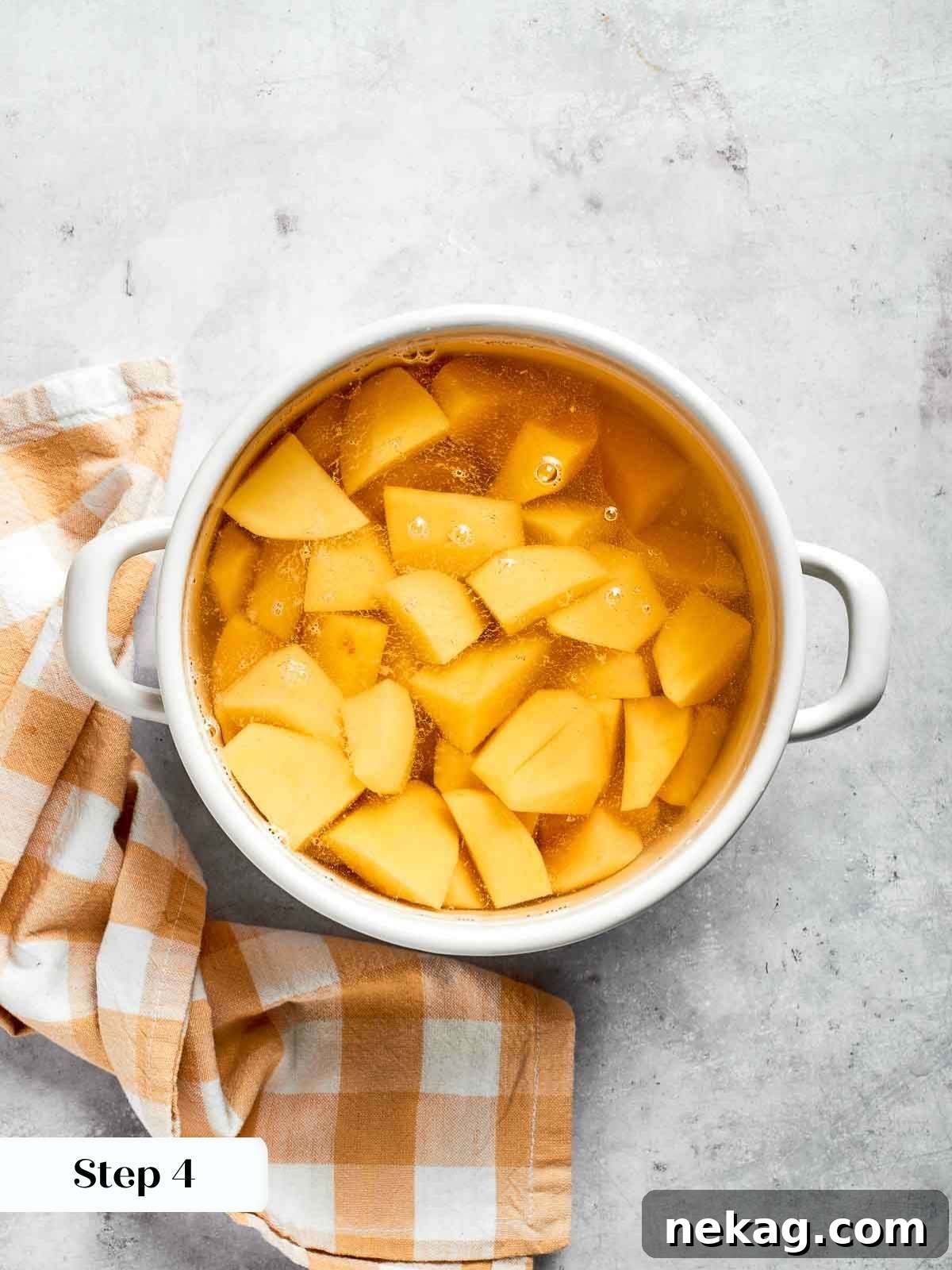 Steaming gold potatoes in a pot of hot water, perfectly tender and ready to be mashed for the Shepherd’s pie topping.
