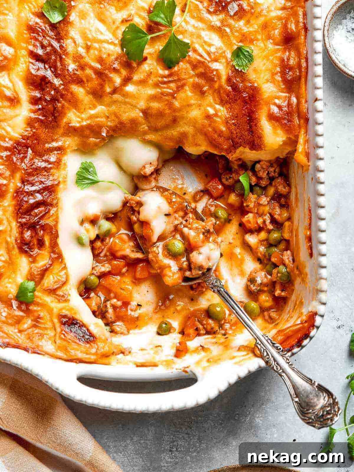 A perfectly baked Chicken Shepherd’s Pie, golden brown and bubbling, presented beautifully in a white baking dish, ready to be served and enjoyed.