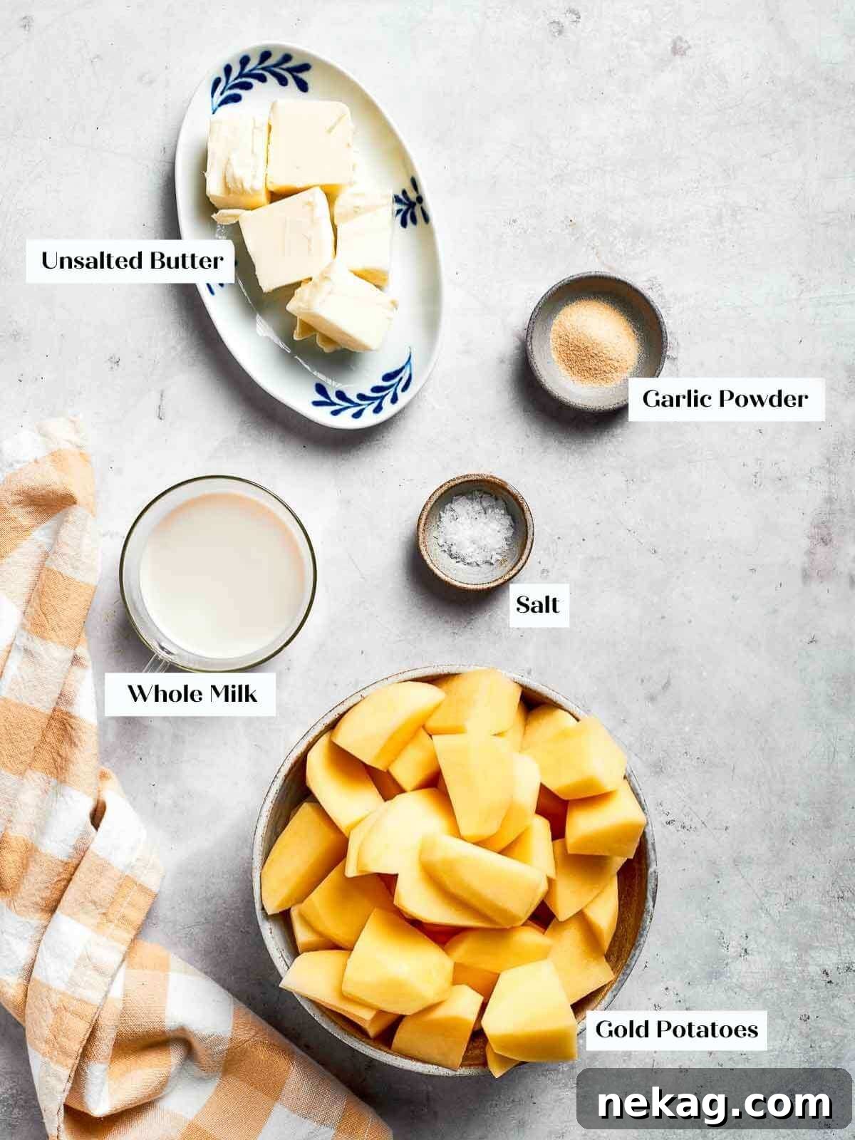 Ingredients for mashed potatoes prepped and ready, featuring gold potatoes, rich butter, kosher salt, and creamy milk in small bowls.