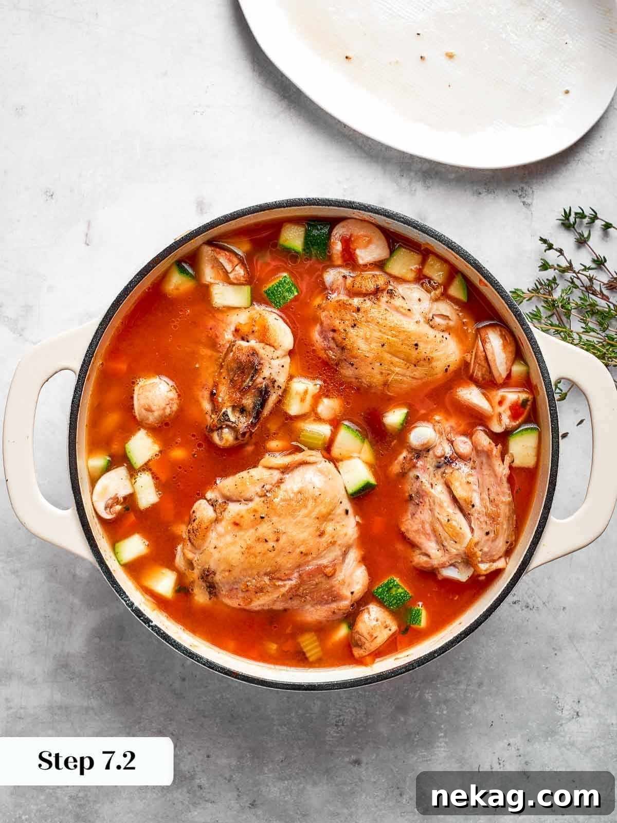 Image showing browned chicken thighs incorporated into the soup pot.