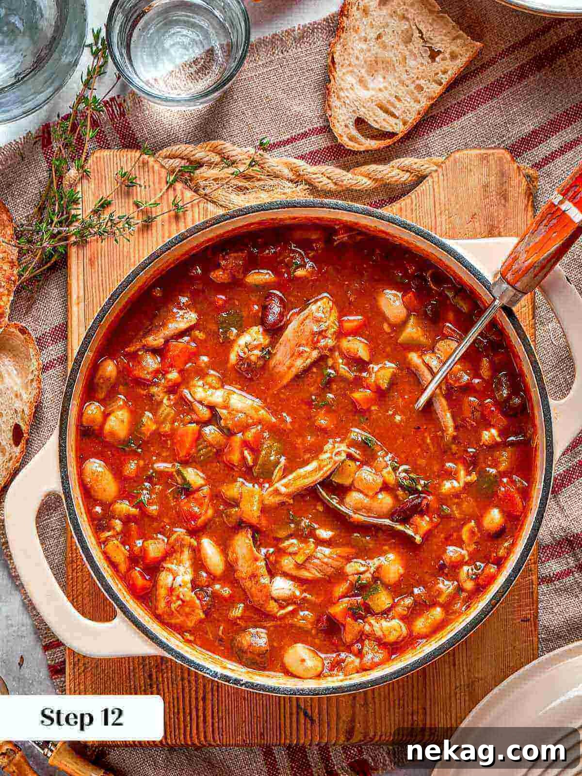 A fully cooked, rich chicken vegetable soup simmering in a Dutch oven.