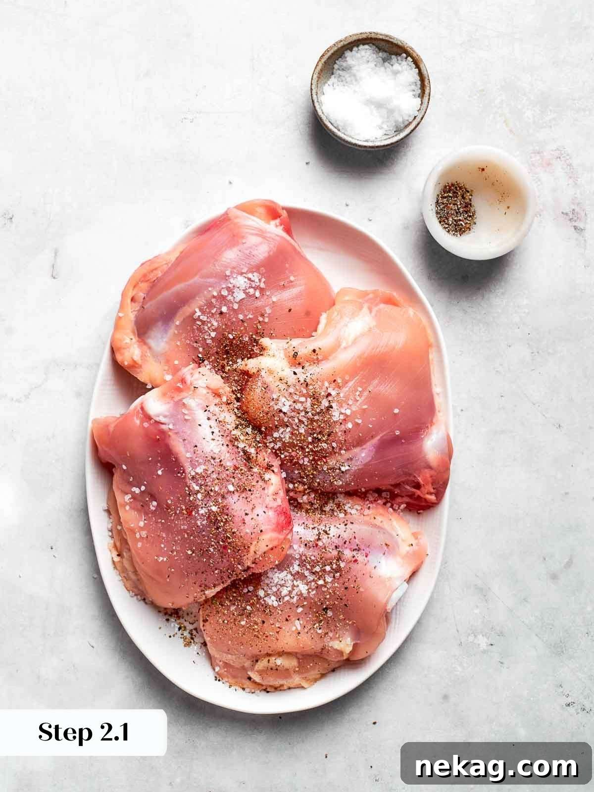 Seasoning chicken thighs with kosher salt before browning.