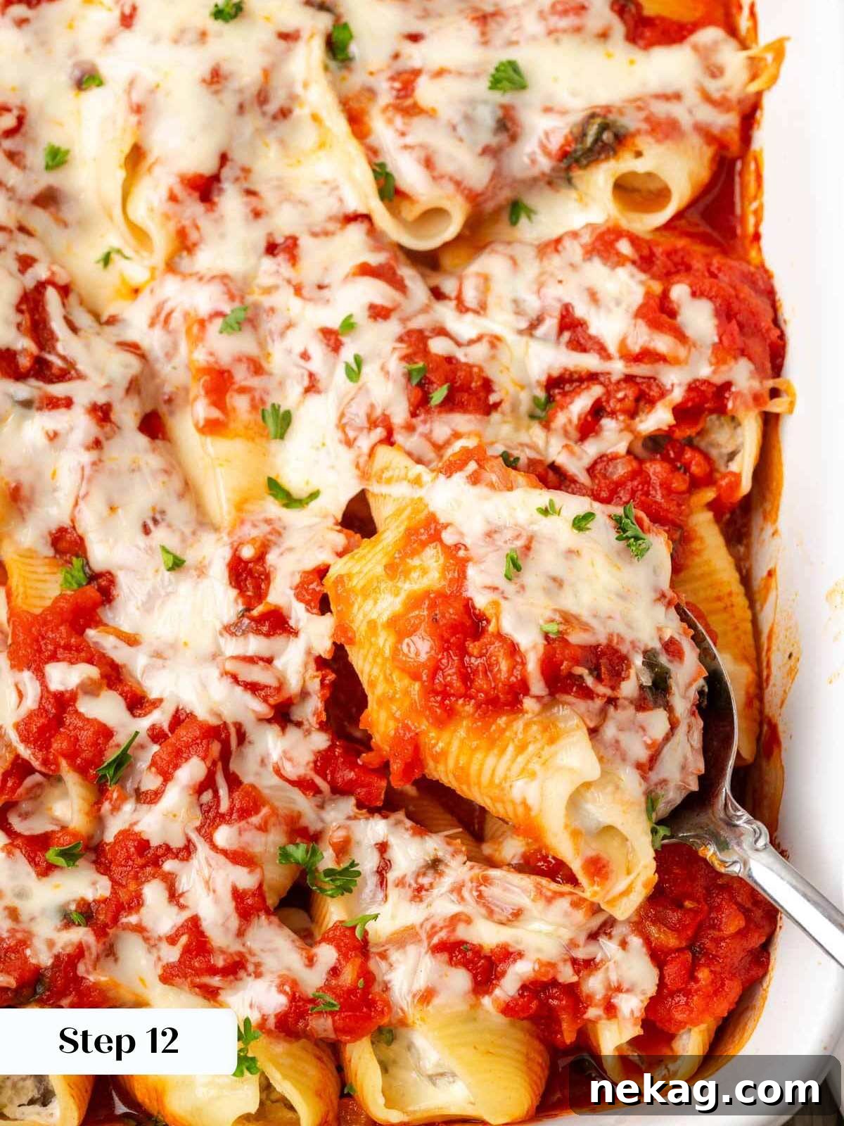 Hearty Meat-Stuffed Pasta Shells 12 A perfectly baked stuffed shell on a spoon, showing gooey melted cheese and rich meat filling.