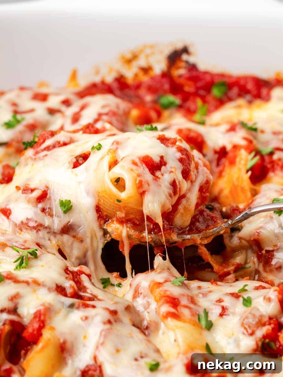 Hearty Meat-Stuffed Pasta Shells 13 Close-up of a stuffed shell on a spoon, with melted cheese stretching appealingly, ready to be eaten.