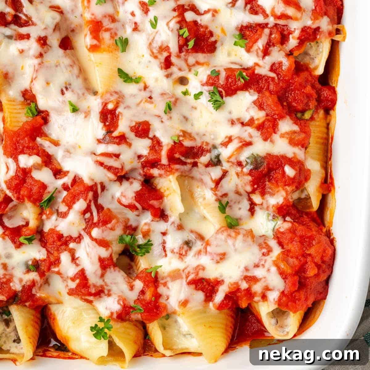 Hearty Meat-Stuffed Pasta Shells 3 Close-up of baked stuffed shells in a baking dish, with golden melted cheese and vibrant sauce.