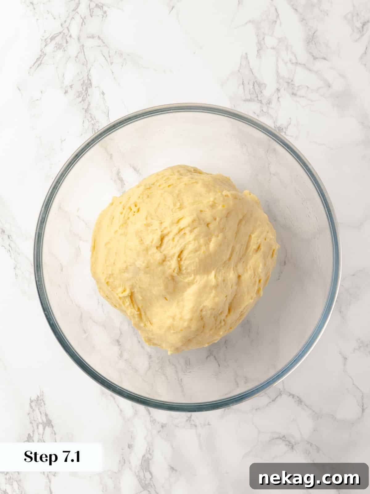 Sticky bun dough resting in a lightly oiled bowl for proofing.