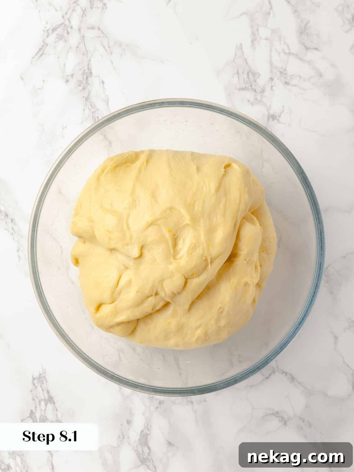 A close-up of dough stretching and folding for structure.
