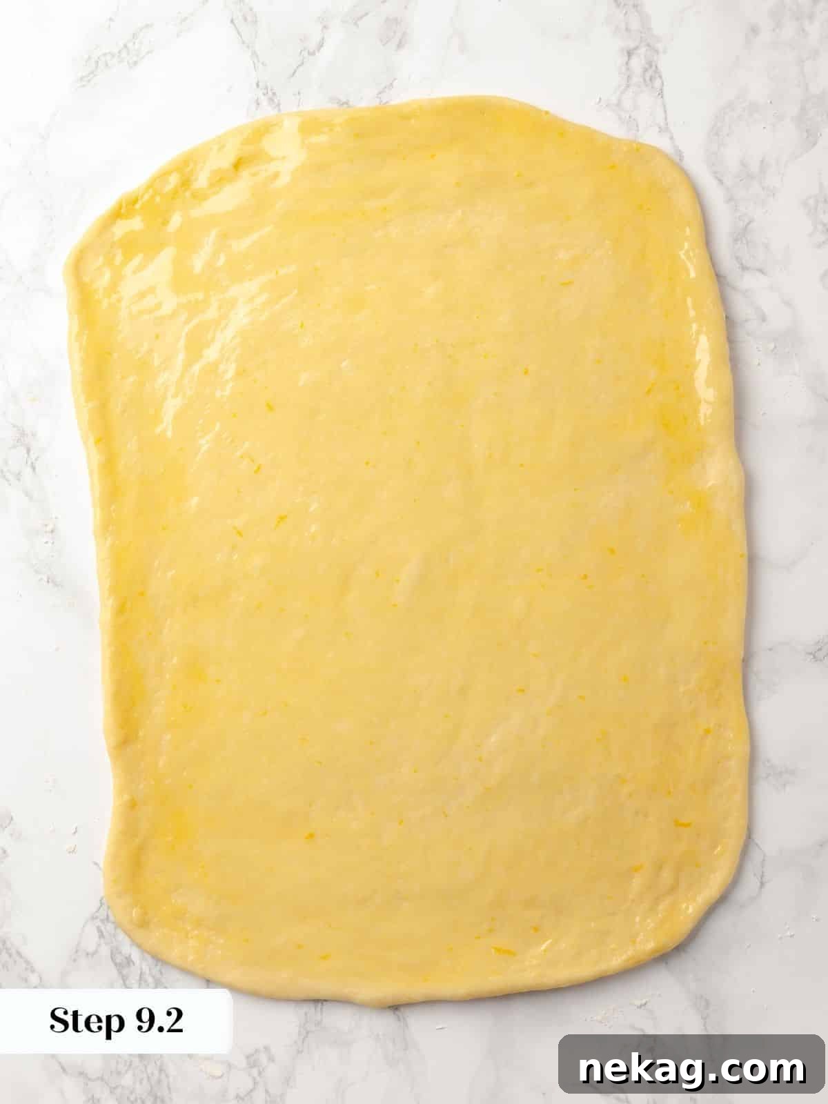 A large sheet of dough brushed with melted butter.