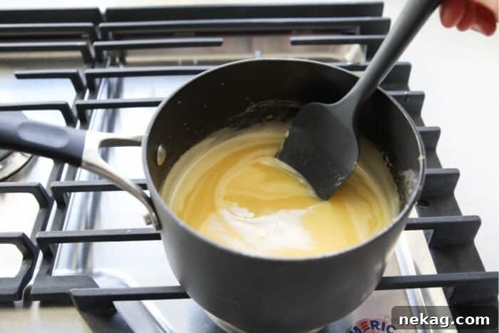 Homemade Lemon Curd Delight 7 Close-up shot of lemon curd simmering and visibly thickening on the stovetop, demonstrating the correct consistency.