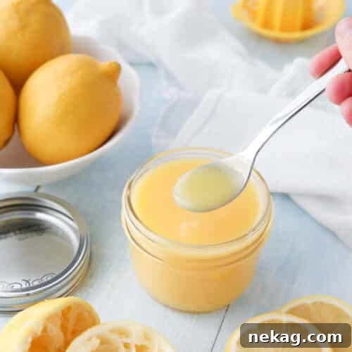 Homemade Lemon Curd on a spoon, showcasing its rich, golden color and thick consistency.