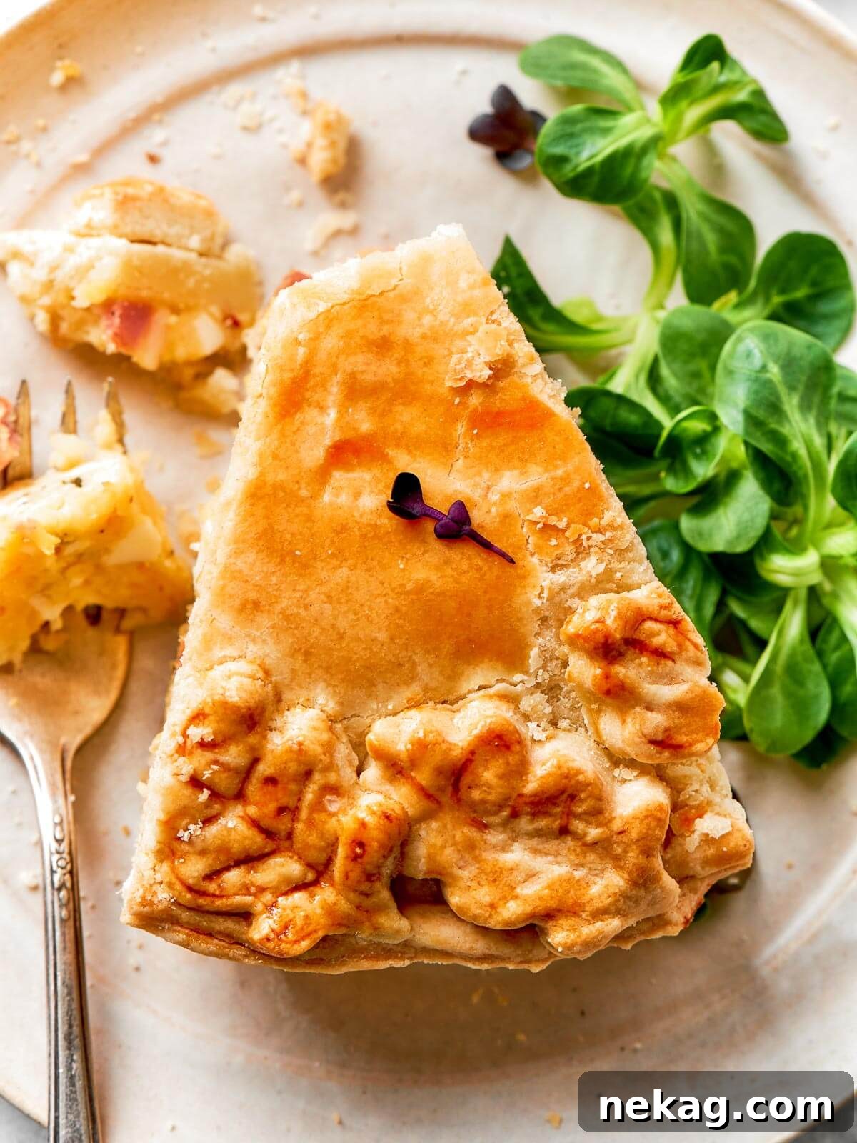 An elegant and beautifully baked pizza rustica, featuring an intricate and ornate decorative pastry top, all baked to a perfect golden perfection.