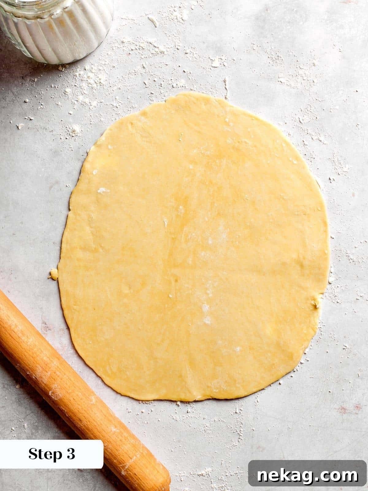 A perfectly even sheet of pie dough skillfully rolled out to the desired thickness, meticulously prepared and ready to line the springform pan with precision.