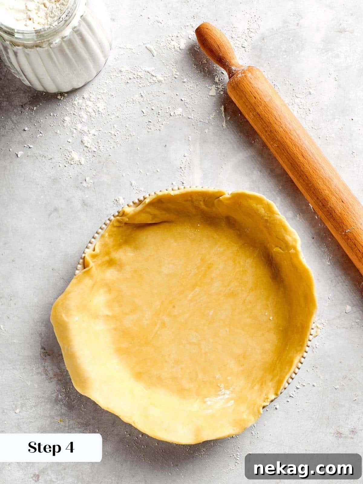 The larger portion of pastry crust carefully lining the springform pan, forming a perfect and seamless base before the savory filling is introduced.