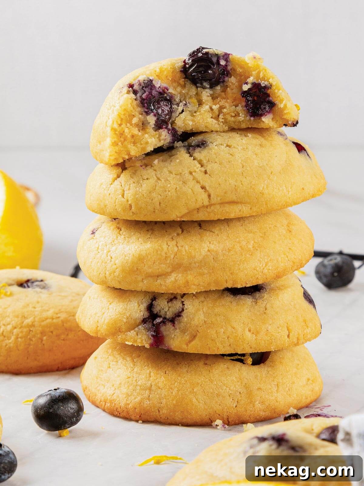 A batch of cookies fully cooled and ready to eat, showing their thick, golden edges and blueberry speckles.