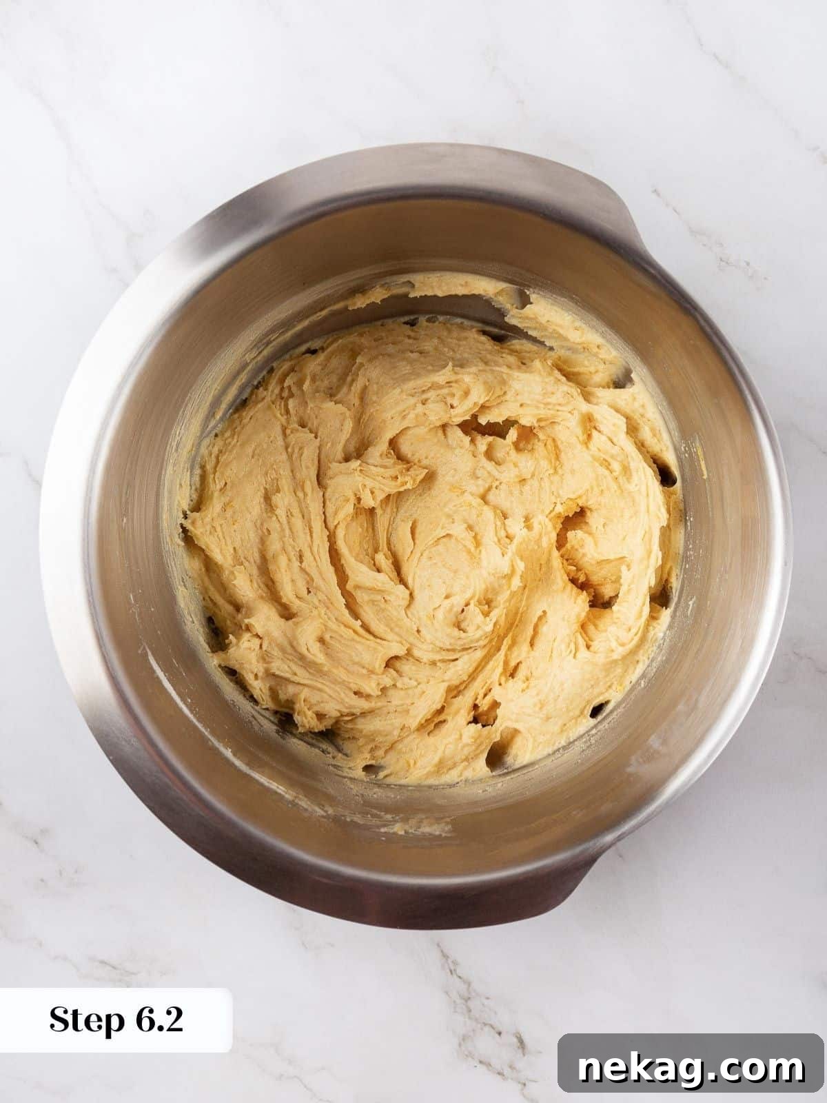 Thick cookie dough with no dry streaks of flour, indicating proper mixing.