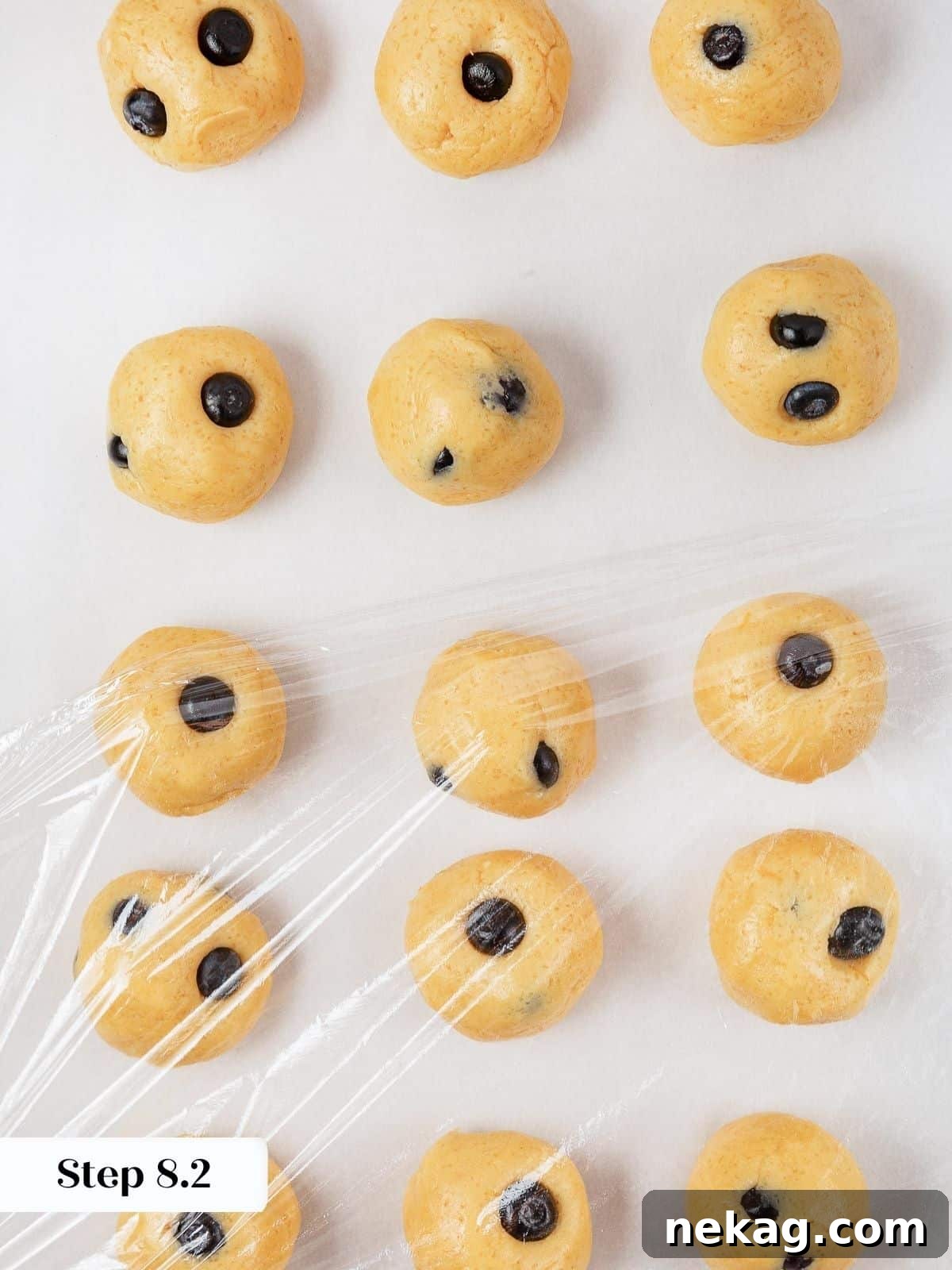 Cookie dough portioned and wrapped in plastic wrap, ready to chill before baking.