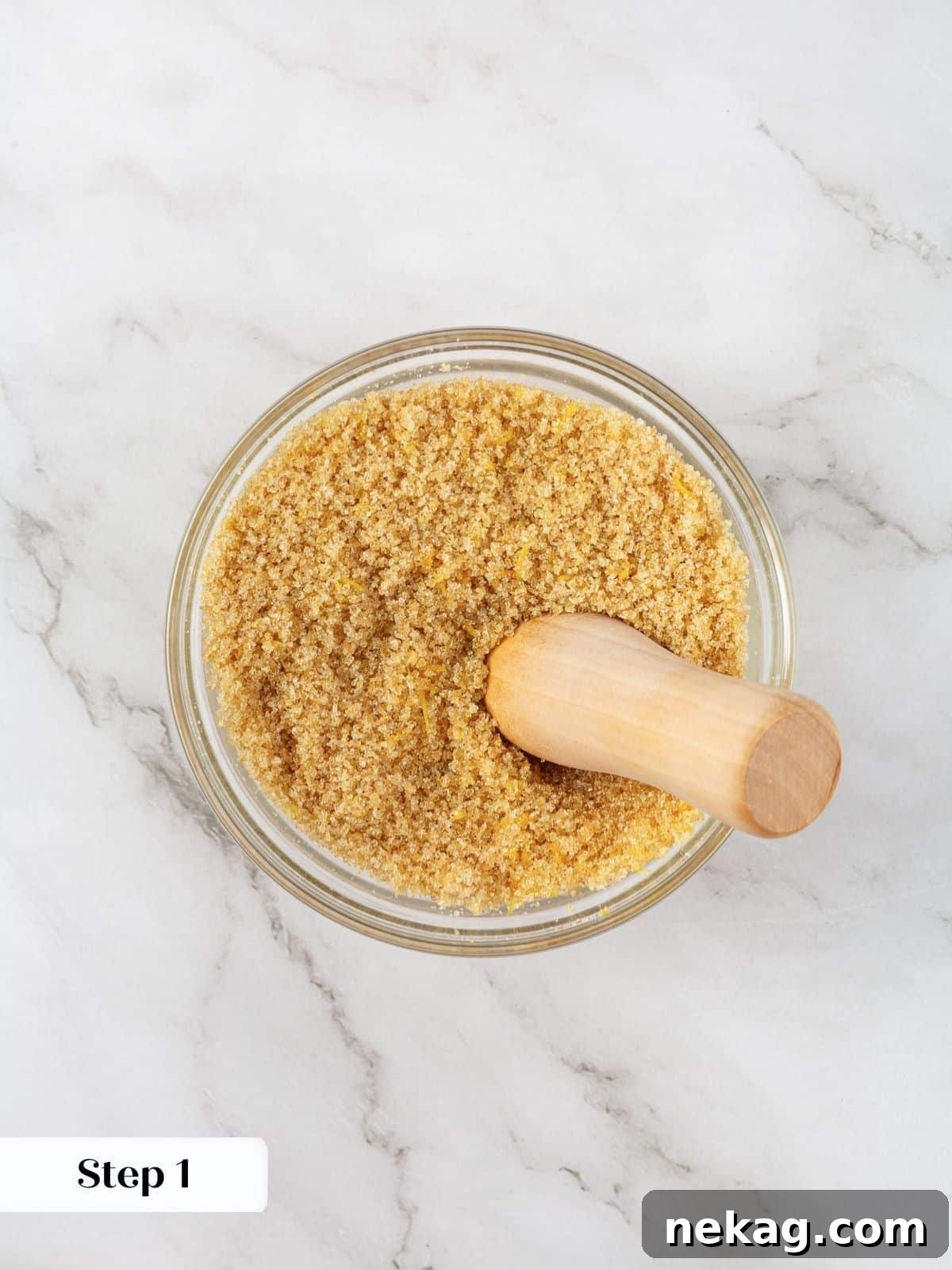A bowl of granulated sugar with fresh lemon zest mixed in, ready for the next step.