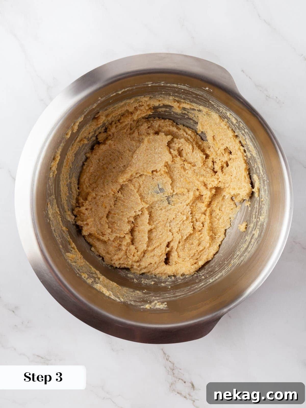Softened butter and lemon-infused sugar being creamed together in a mixing bowl.