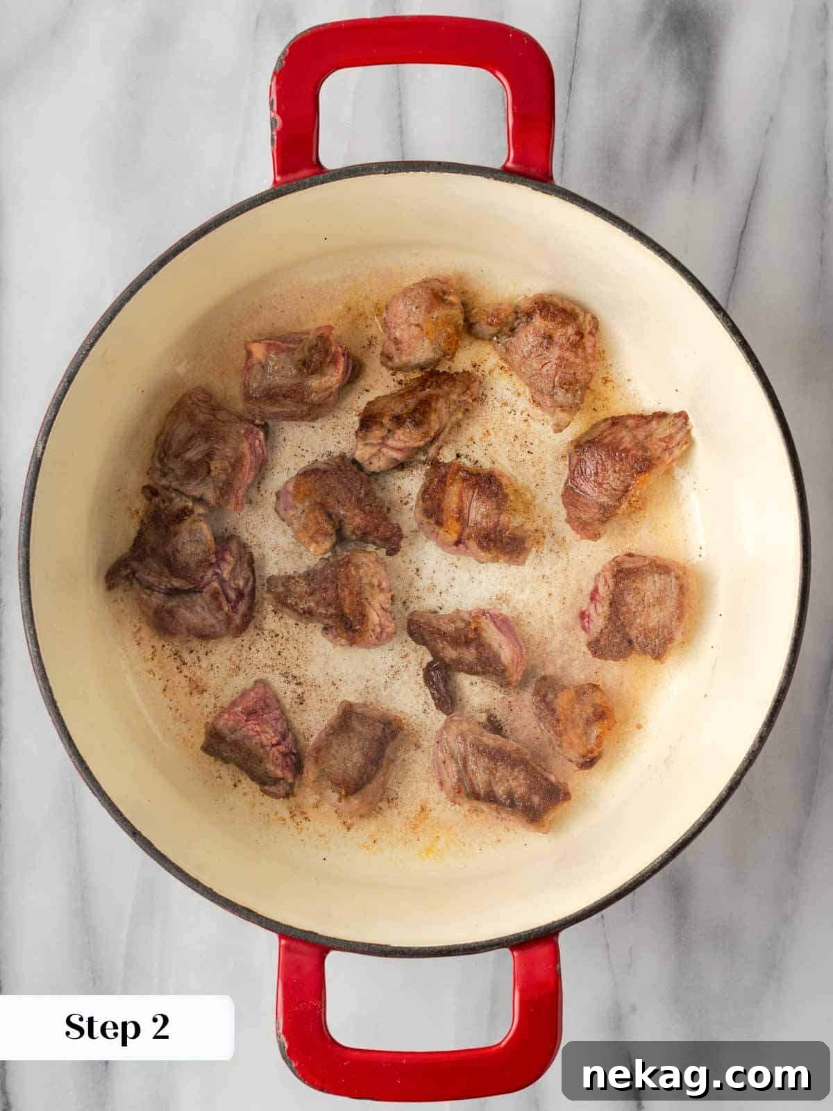 Browning cubed steak in a Dutch oven with olive oil over medium heat.