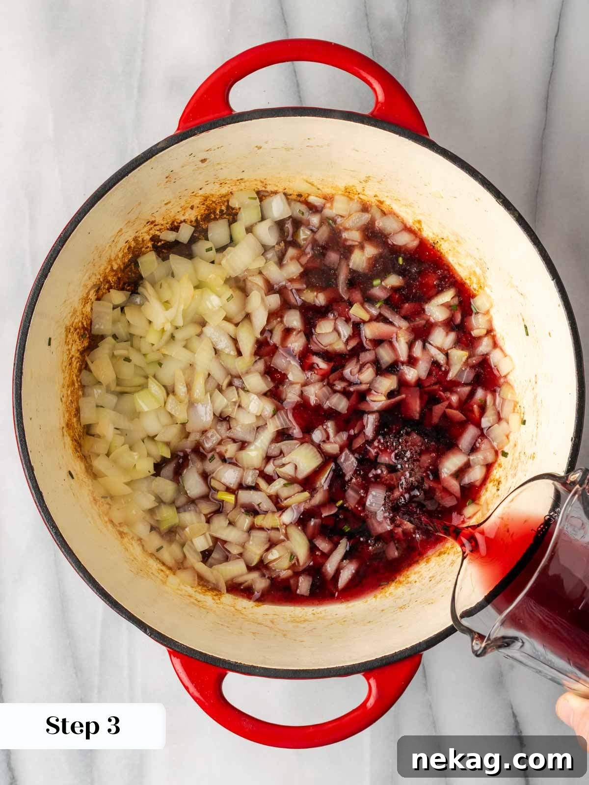 Adding red wine to the pot after sautéing onions and rosemary to deglaze the flavorful browned bits.