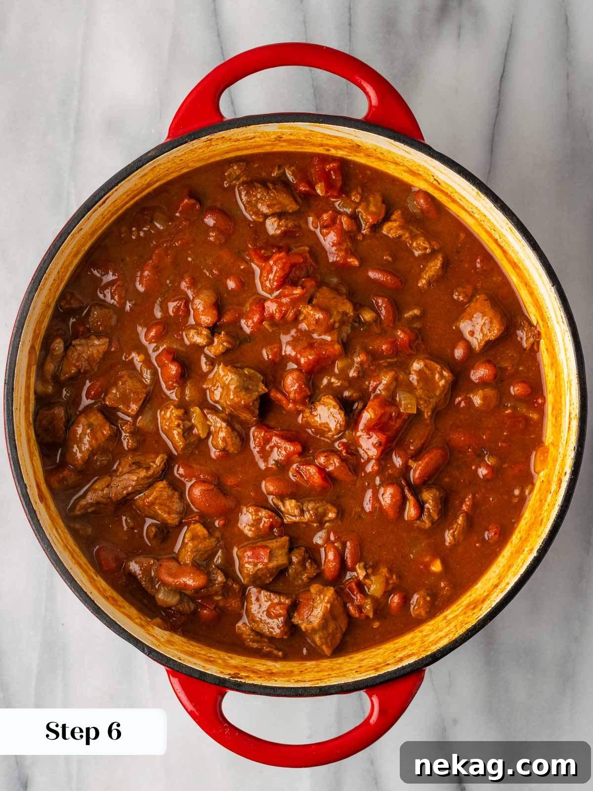 Fully cooked rosemary pinot noir steak chili simmering in a Dutch oven just before serving.