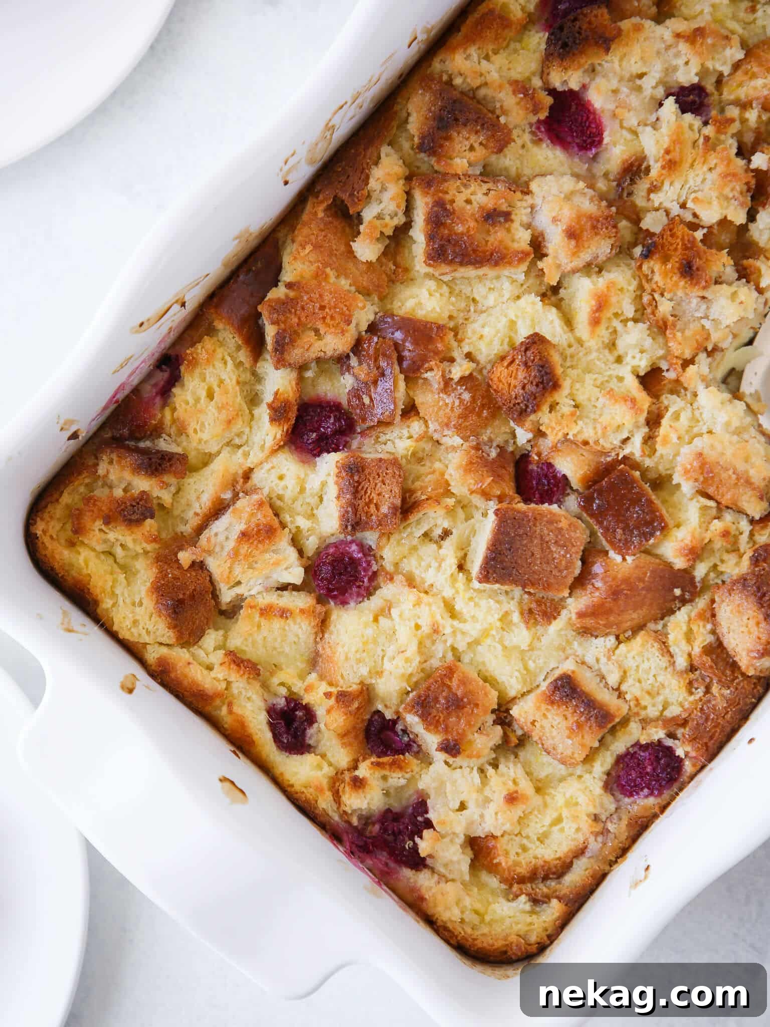 Lemon Raspberry Bread Pudding unsliced in white baking dish, ready to be served