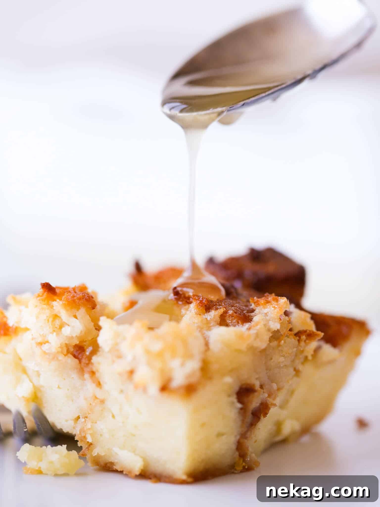 A perfect slice of Lemon Raspberry Bread Pudding drizzled with lemon glaze, ready to enjoy