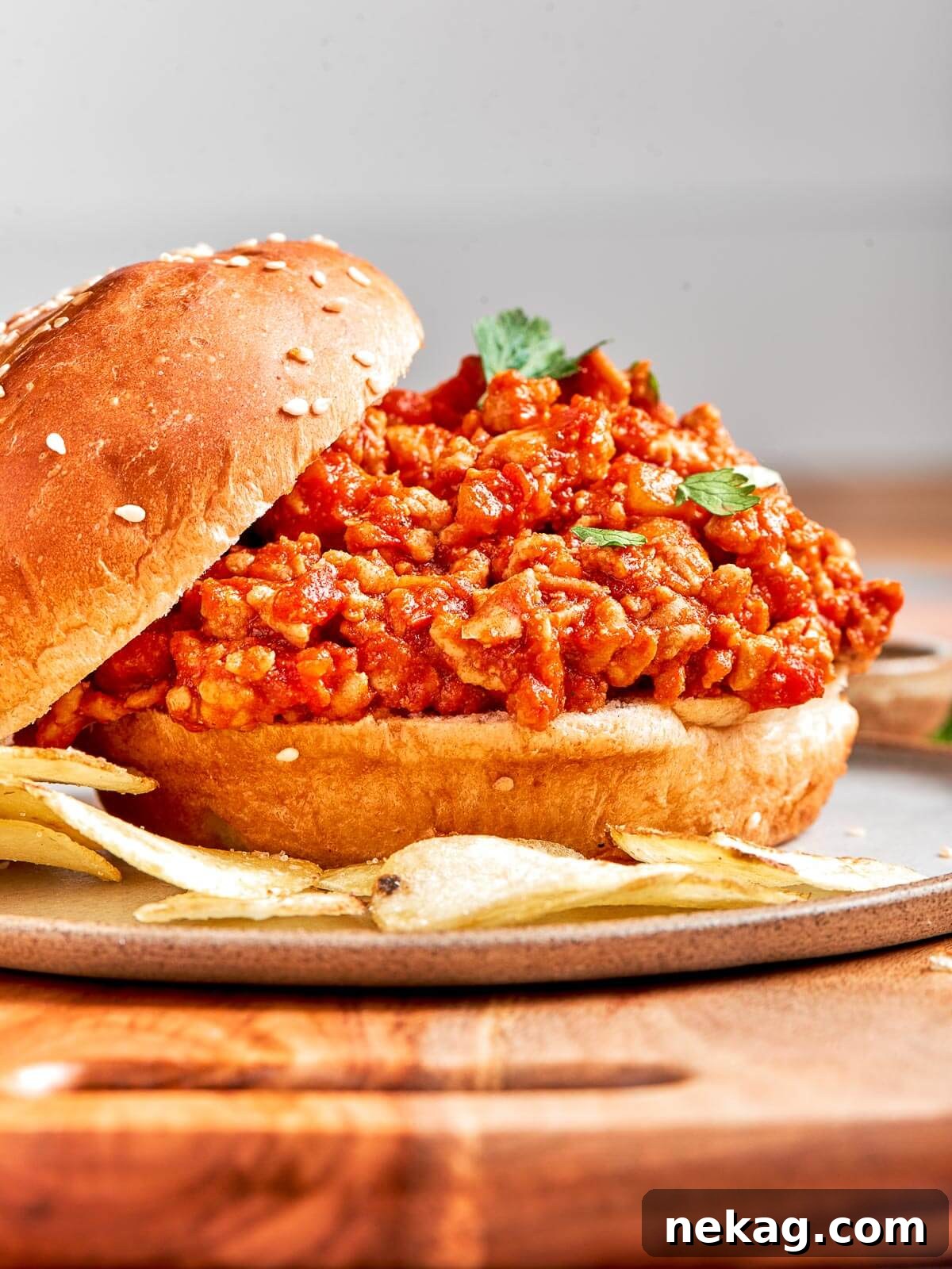 A hearty helping of turkey sloppy joe filling spilling out of a soft bun, ready to be enjoyed.