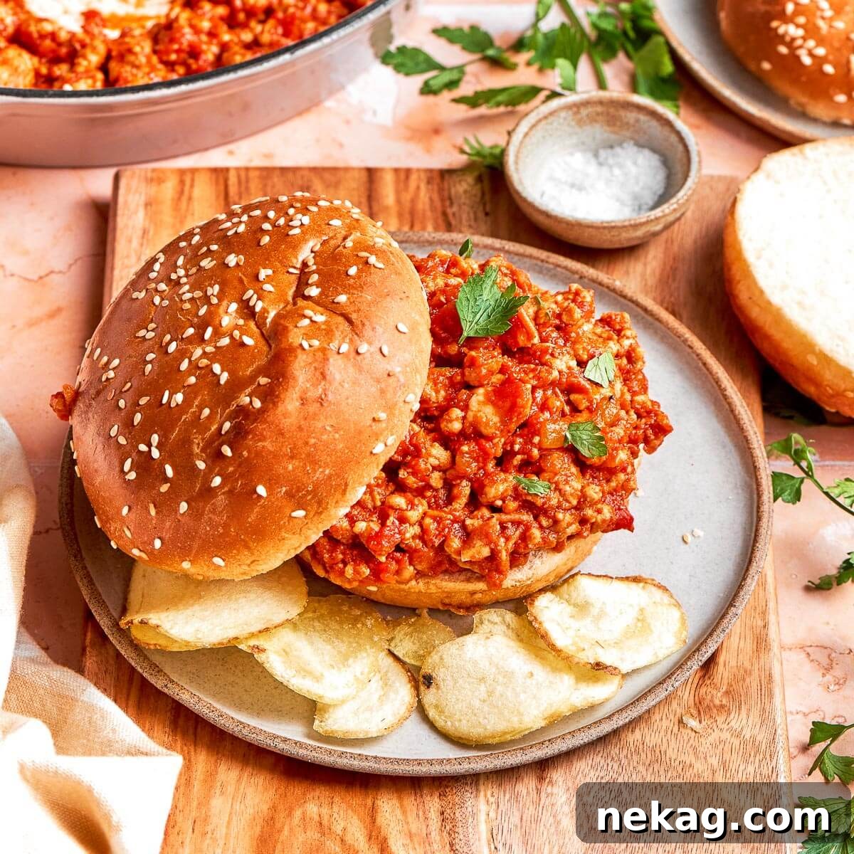 Plated turkey sloppy joes nestled in soft hamburger buns, garnished and ready to serve for dinner.